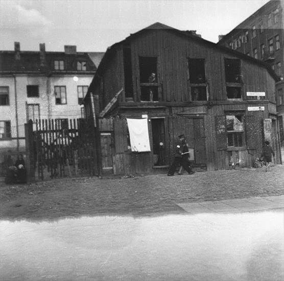 archiwalne fotogr... - A Jewish policeman leads away a person he has just arrested in the Warsaw ghetto.jpg